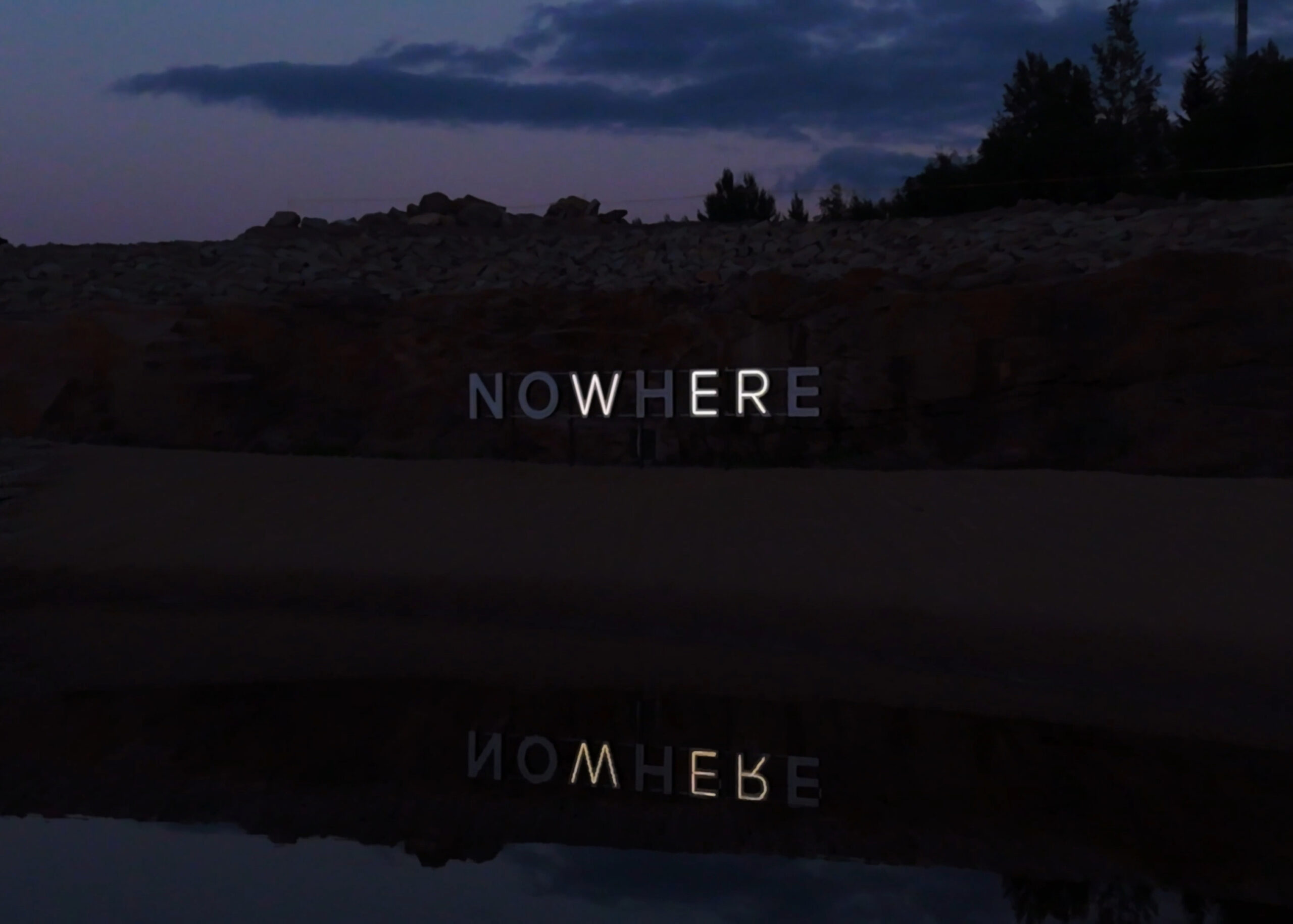NOW/HERE, kinetic neon work by Timo Aho: neon letters glow white with letters "WER" lit at this moment.