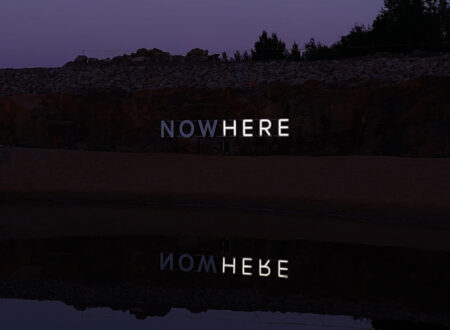 NOW/HERE, kinetic neon work by Timo Aho: neon letters glow white with only [some letters / the word "HERE"] lit at this moment.
